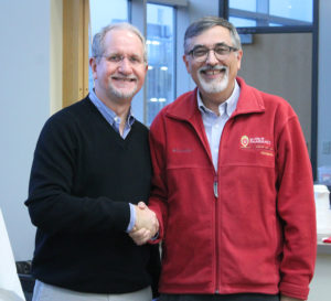 AIHP Executive Director-designate Dennis Birke (left) shakes hands with AIHP Executive Director Greg Higby.